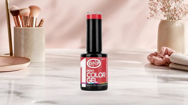 Manos con uñas esmaltadas en rojo coral brillante usando esmalte semipermanente GNP de un paso